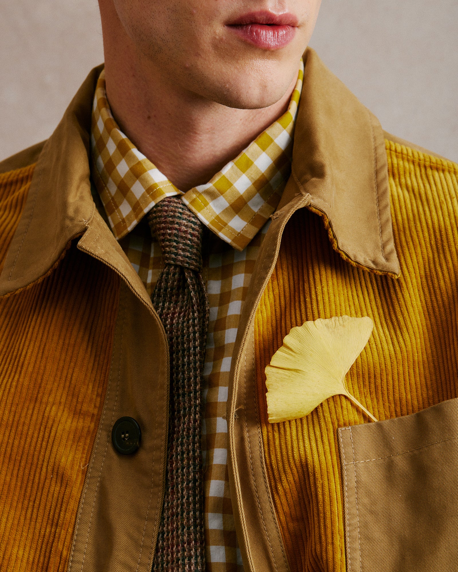 Rovi Lucca FW24 Orto Botanico – unlined garden jacket in khaki and gold cotton with a corded velvet panel, paired with a 100% cotton flannel shirt in gold and white vichy pattern with a contrasting khaki and white check pocket, and a 100% Shetland wool neck tie.