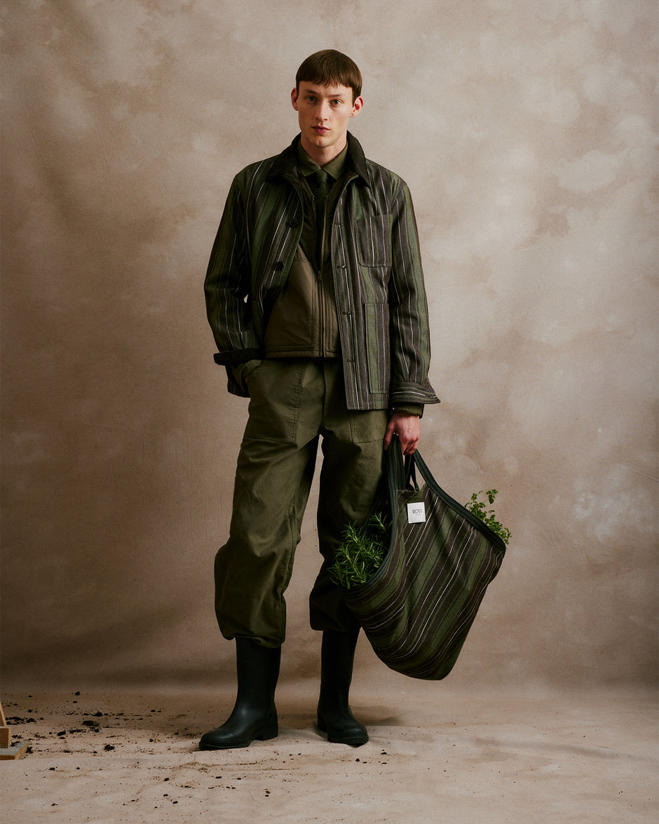 Rovi Lucca FW24 Orto Botanico – Khaki and Brown striped garden jacket, quilted with a mix of cotton, wool, and synthetic fibers, featuring corded velvet details. Quilted garden vest in matching Khaki and Brown, paired with garden pants in Lovat cotton twill. Long-sleeve garden shirt in Lovat cotton flannel with a contrasting Shetland wool pocket, finished with a Shetland wool neck tie in Lovat. Garden tote in Khaki and Brown stripes, lined with cotton twill in Lovat.
